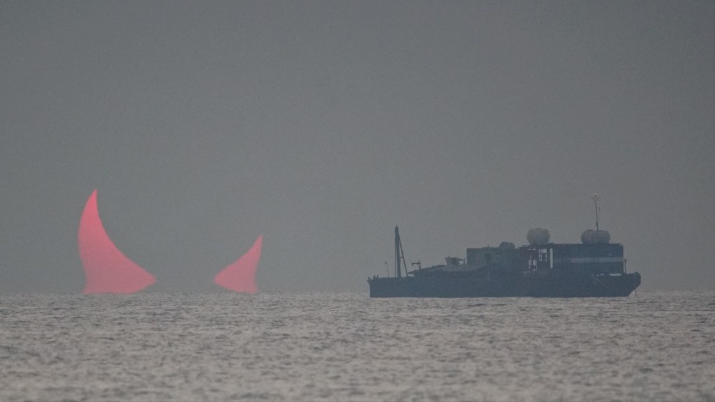 The sun, partially blocked by the moon, rises above the sea in Al Wakrah, Qatar, Dec. 26, 2019.